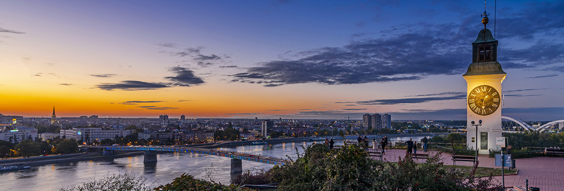 Petrovaradin Fortress clock tower overlooking Novi Sad and the Danube at sunset