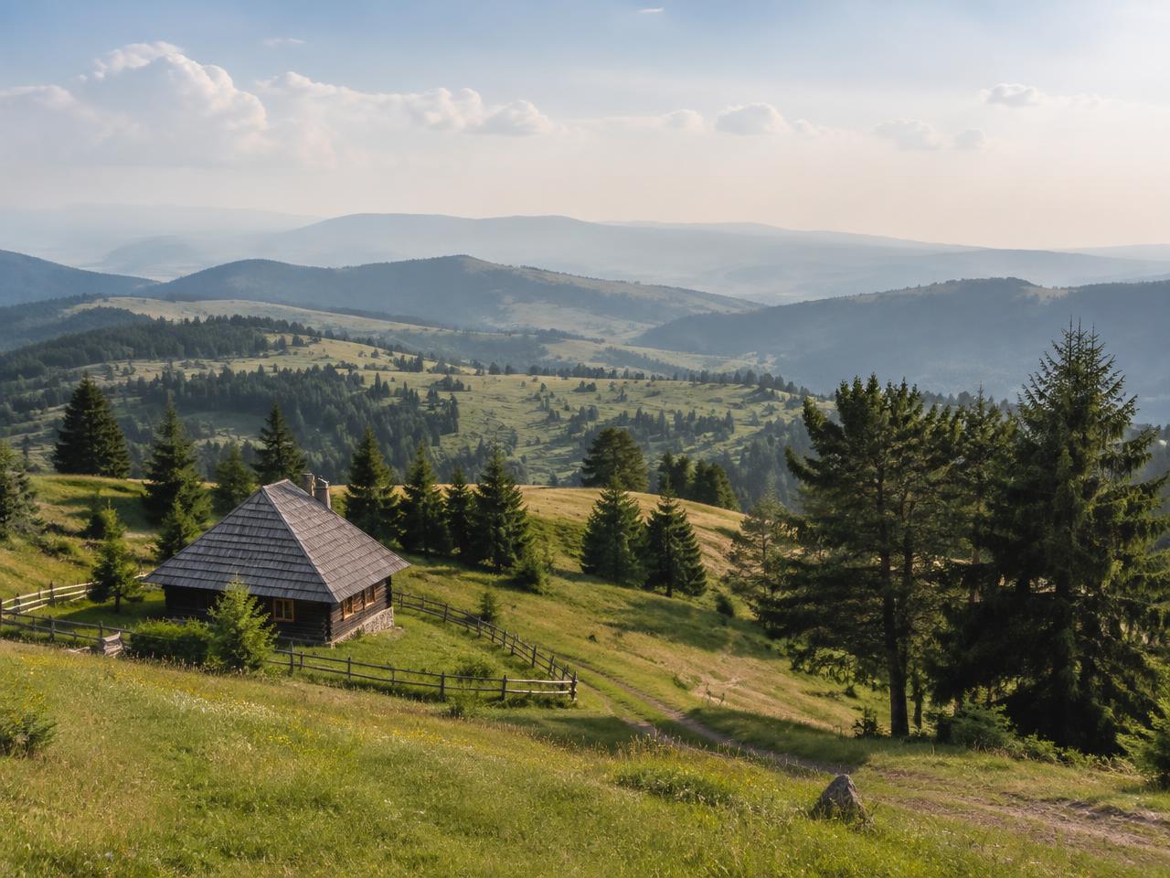 Rolling meadows and wooden houses on the Zlatibor plateau